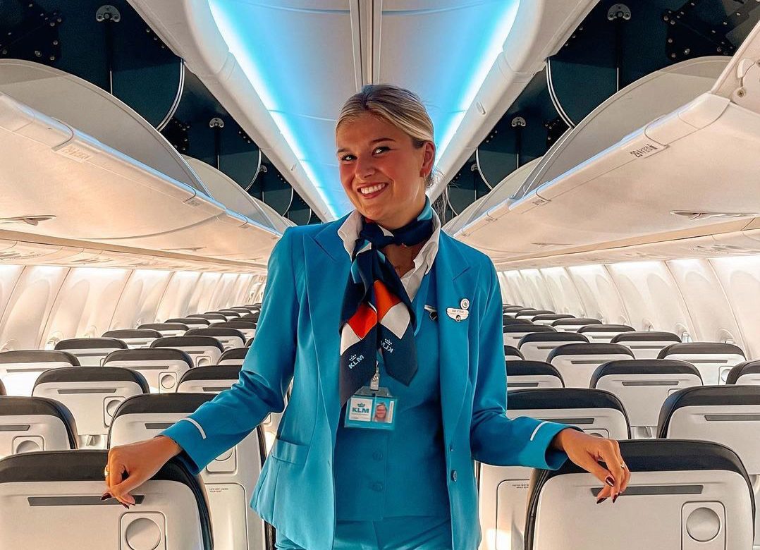 Esther stood in the isle of a plane in her uniform