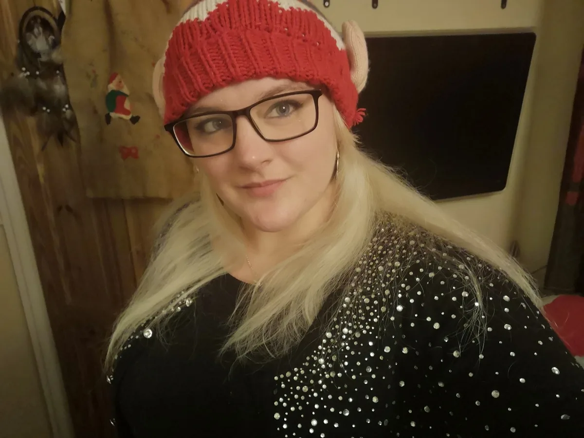 Louise is pictured wearing a red beanie and jumper.