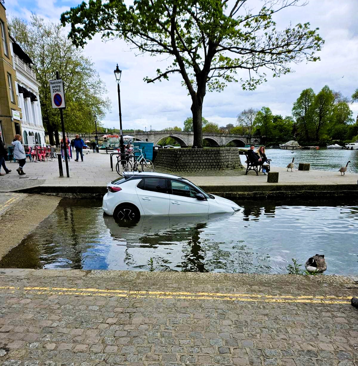 A driver's mishap leaves their car submerged underwater after parking on a river slipway in Richmond. Firefighters rescue the stranded vehicle.