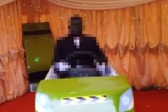 A deceased cabbie in Ghana was buried upright in a taxi-shaped coffin with his hands on the steering wheel. The unique funeral featured the coffin spinning on a stand.