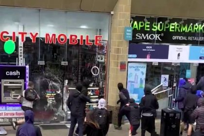 Far-right mob attempts to loot vape shop during a daylight rampage in Manchester. Police intervene quickly as shocked onlookers, including trans pride attendees, seek safety.