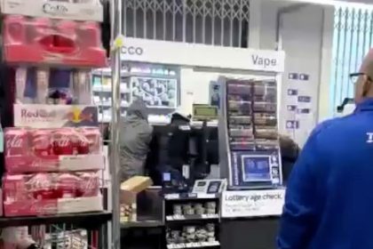 Masked thieves raid Tesco Express in London, looting tobacco and spirits as shocked staff watch; public criticizes lack of intervention. Police investigation ongoing.