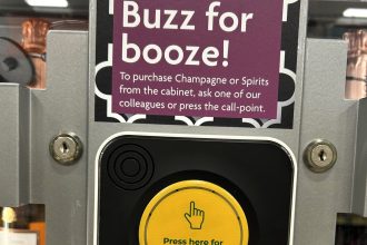 Affluent town shoppers criticize Morrisons for securing champagne in a locked cabinet, requiring a buzzer to purchase, sparking debate over shoplifting and service delays.