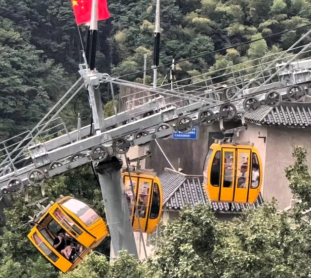 A tourist fell 30ft from a cable car in China after strong winds caused the doors to open. She survived with non-life-threatening injuries. An investigation is ongoing.