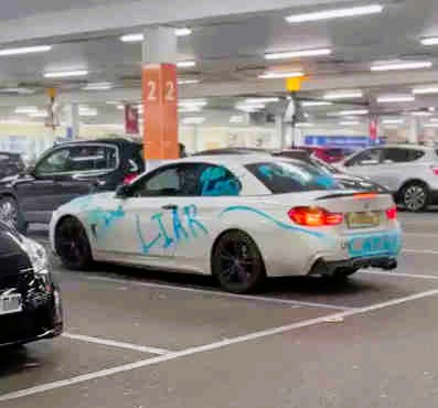 BMW driver’s car vandalized with “Cheater” and “Liar” graffiti at Tesco Extra in Slough, leaving locals amused and sparking jokes about the driver’s love life.