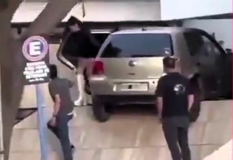 Drunk driver crashes car into police station wall in Neuquén, Argentina, hanging off the ground; both occupants over the legal limit but escape unharmed.