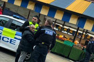 Quick-thinking busker serenades man being arrested with Akon’s ‘Locked Up’ in Dudley. The impromptu performance leaves officers amused as the scene unfolds.