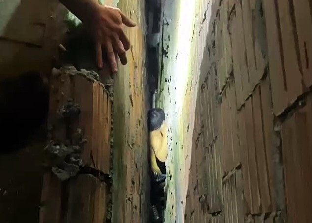 Firefighters in Manaus rescue man stuck in a narrow gap between walls after a rooftop fall. Dramatic footage shows the careful wall demolition needed to free him safely.