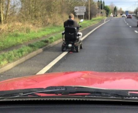 Mobility scooter rider causes chaos on A14, dodging police and oncoming traffic at 8mph. Witnesses stunned as tailbacks and safety concerns escalate.