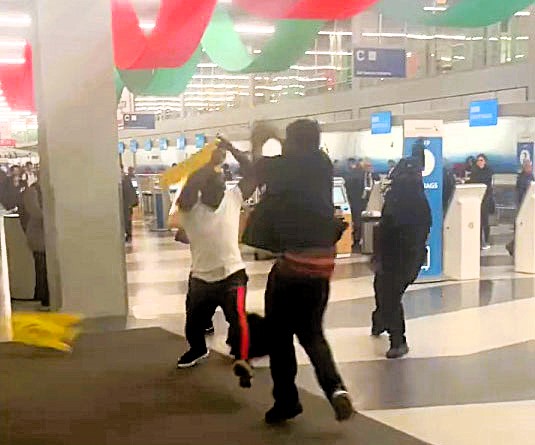 Chaos erupts at Chicago O’Hare Airport as passengers and staff clash in a wild brawl using wet floor signs and stanchion poles. No arrests made; investigation ongoing.