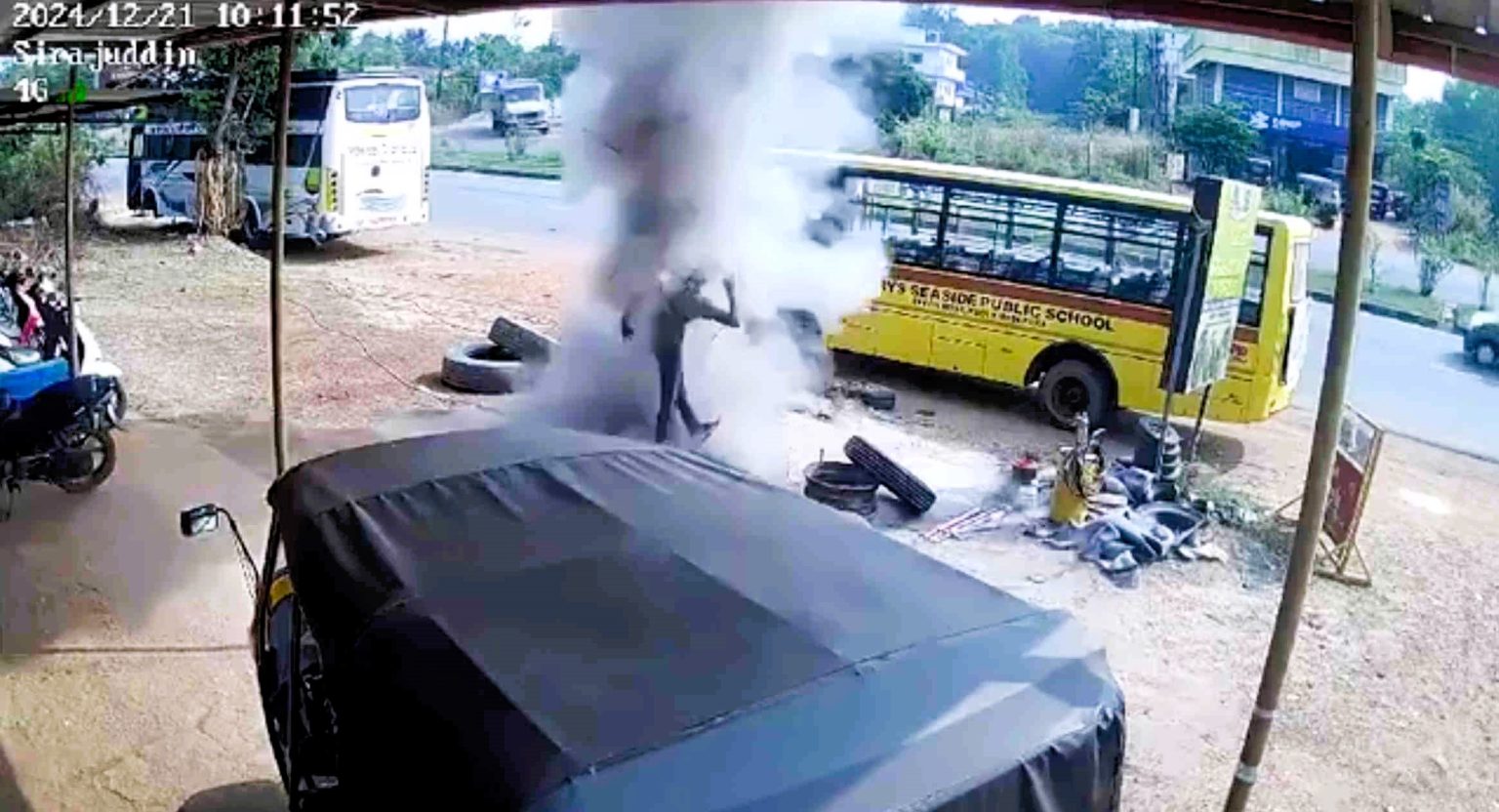 A 19-year-old garage worker is critically injured after a school bus tyre exploded, throwing him 6ft into the air. The freak accident near Mumbai was caught on CCTV.