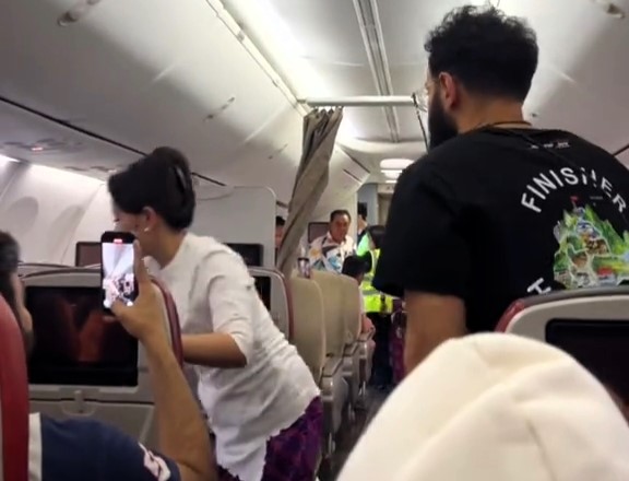 A woman caused a one-hour flight delay after refusing to wear a seatbelt on a Vietnam-Malaysia flight. Police removed her as passengers cheered, sparking viral reactions.