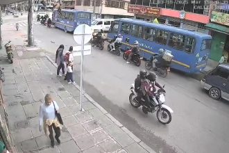 A jaywalker caused a crash in Bogotá after stepping into traffic, sending a biker and passenger into a family on the pavement - all escaped with minor injuries.