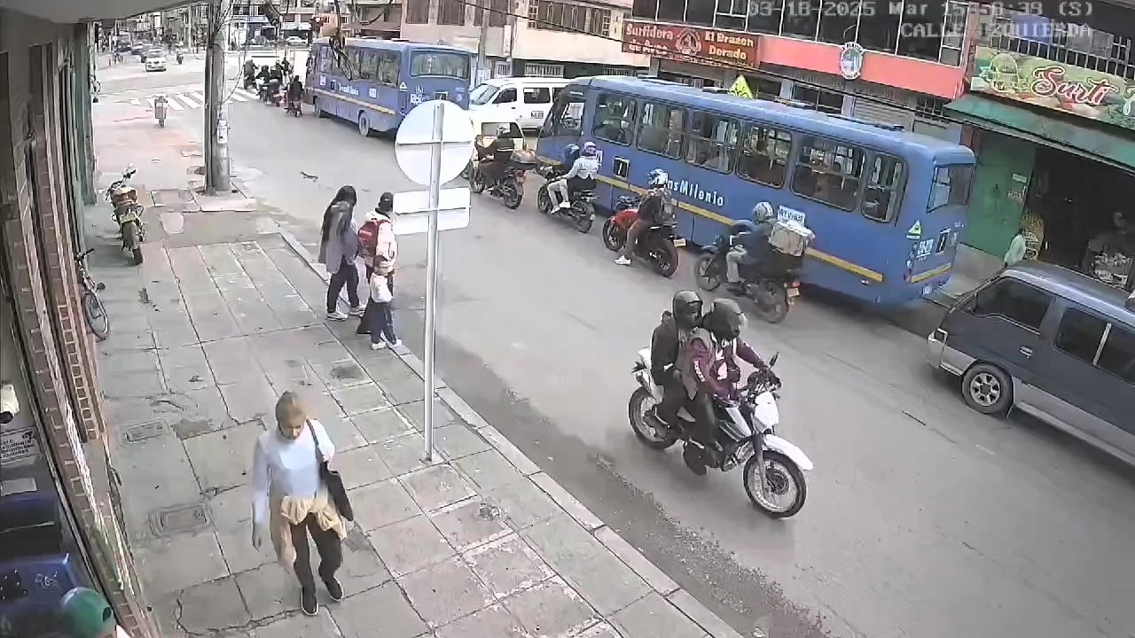 A jaywalker caused a crash in Bogotá after stepping into traffic, sending a biker and passenger into a family on the pavement - all escaped with minor injuries.