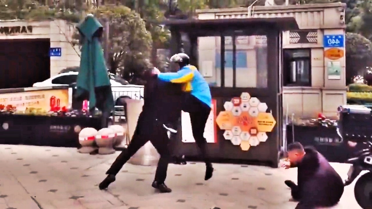 A delivery driver in China unleashed kung fu-style moves on security guards in a dramatic street fight, knocking them down with kicks and punches before bystanders intervened.