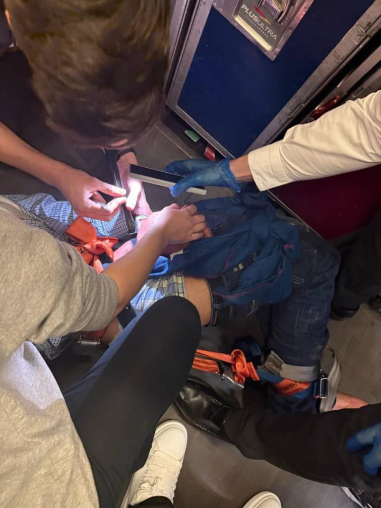 A passenger on a Plus Ultra flight from Madrid to Caracas caused panic by trying to open an emergency exit mid-air. He was restrained by crew and detained on landing.