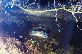 A driver was rescued from a submerged BMW in a Suffolk pond after police found him trapped in an air pocket. Officers acted fast, saving his life just in time.