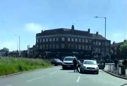 Two drivers brought traffic to a halt in a Wrestlemania-style road rage brawl at Kingsbury Circle, London, trading punches in a dramatic fistfight caught on camera.
