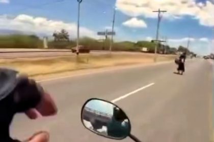 Woman narrowly avoids death after strolling across busy Honduran motorway - biker's camera captures terrifying near-miss as pickup swerves and crashes to avoid her.