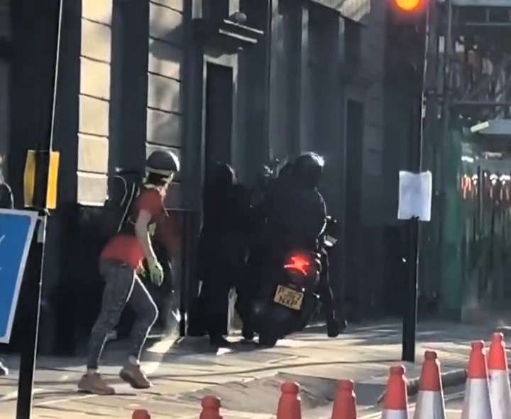 Woman has handbag stolen by moped muggers outside London strip club - scooter mounts pavement as passenger swipes bag and speeds off, sparking outrage from locals.