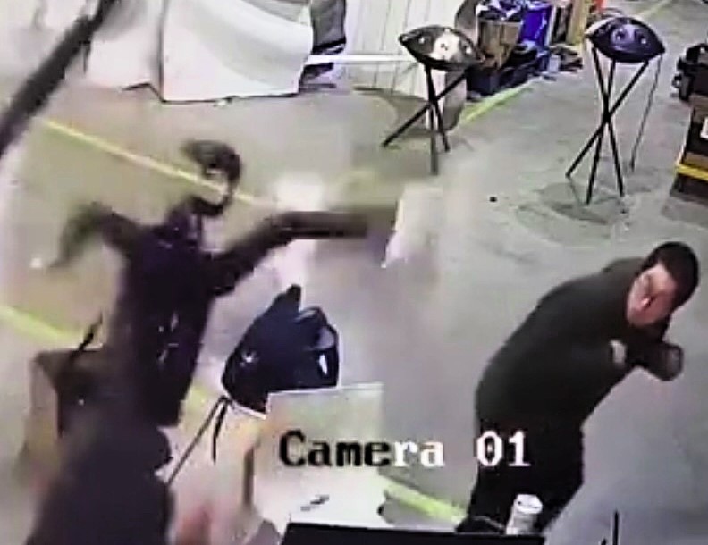 CCTV footage shows a humanoid robot lashing out on a factory floor, startling workers as it thrashed violently before being restrained by a crane. Cause remains unclear.