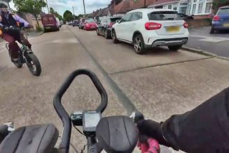 A Just Eat e-bike rider nearly collided with a cyclist at a T-junction in Hounslow, sparking debate over road safety after helmet cam footage surfaced.