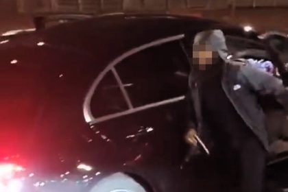 Driver crashes black Mercedes in Poplar while holding a laughing gas balloon - clambers out clutching it before fleeing scene as confused passenger follows behind.