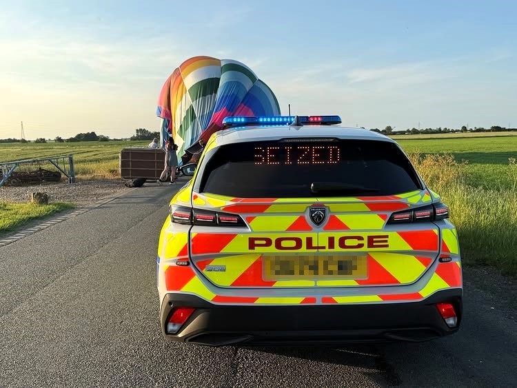 A hot air balloon pilot got a lighthearted warning from police after landing on a rural Cambridgeshire road, with officers joking about parking and insurance.