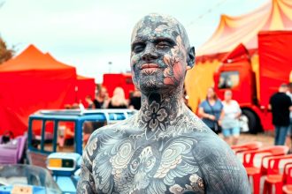 Tattooed teacher Sylvain, aka FreakyHoody, is adding a second layer of ink to his full-body suit, aiming to be the world’s most tattooed educator while still inspiring students.