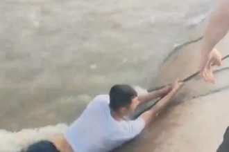 A man was swept 17 miles down a fast-moving canal in Xinjiang, China, before being rescued after a 35-minute chase by police using ropes, cars, and e-bikes. He survived unharmed.