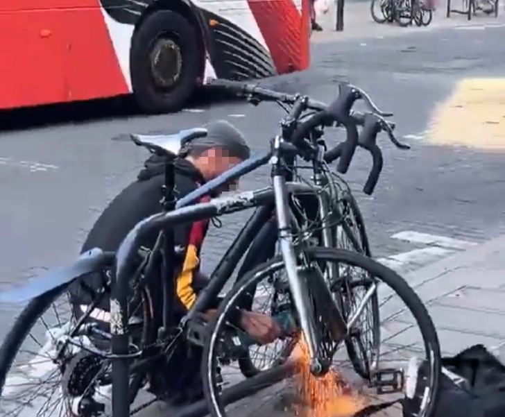 A man was caught on camera using an angle grinder to cut a bike lock outside Marks and Spencer in Dalston, London, sparking outrage and disbelief from shocked onlookers.