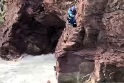 Two people trapped by rising tide on unsteady cliff at Greenaway Beach rescued in daring rope operation as huge waves crash below during spring tide conditions.