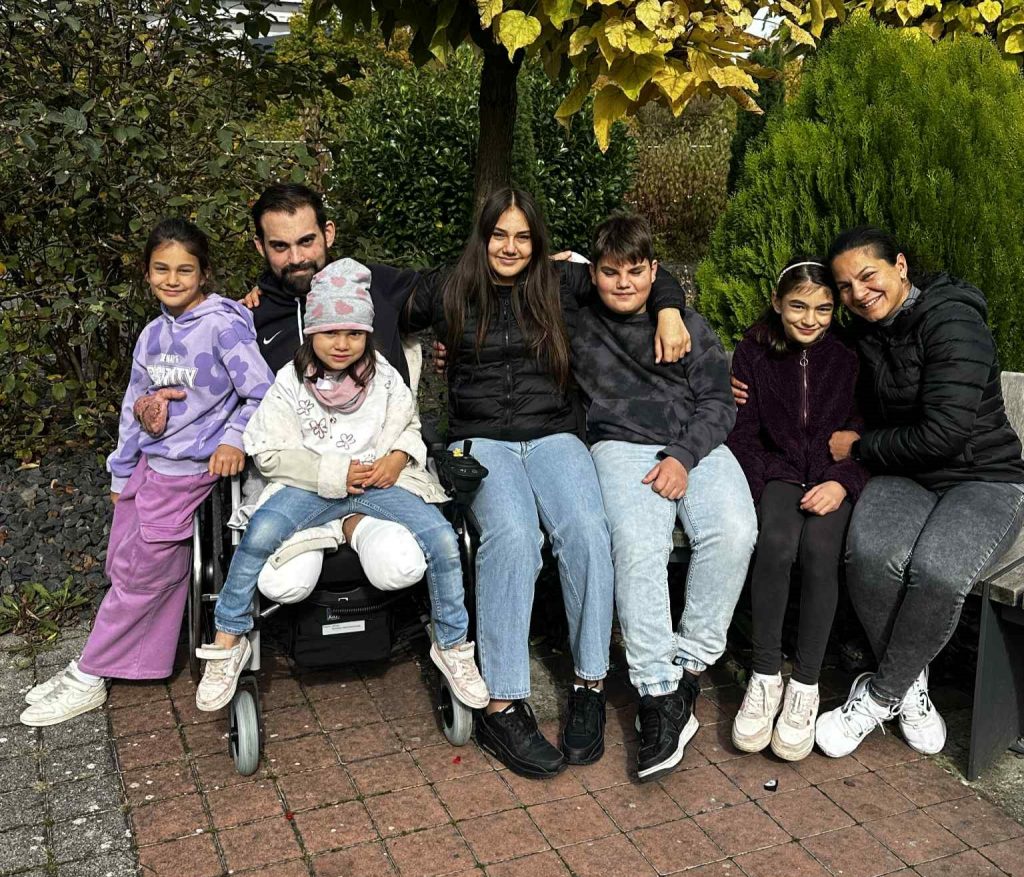 A dad-of-five lost his legs and fingers to a rare infection on holiday. Now, his wife carries him up 5 floors daily while fundraising for an external elevator.