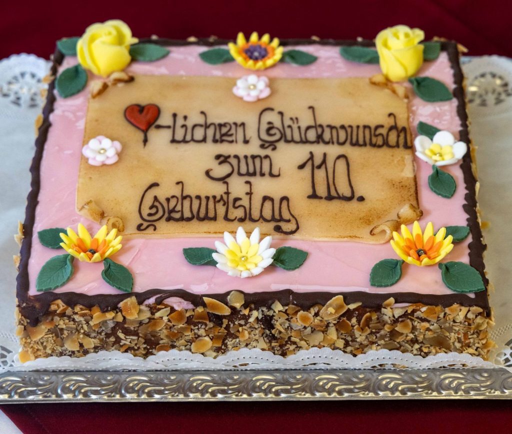 Sweet-toothed Emma Wenda celebrated her 110th birthday with a rum-soaked cake, marking a life spanning two world wars, a helicopter ride at 95 and new teeth at 103.