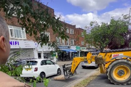 Fiat 500 lifted by JCB after crash with BMW causes traffic chaos in Chigwell as construction workers step in to clear road in dramatic footage cheered by pedestrians.