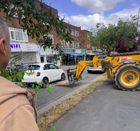 Fiat 500 lifted by JCB after crash with BMW causes traffic chaos in Chigwell as construction workers step in to clear road in dramatic footage cheered by pedestrians.