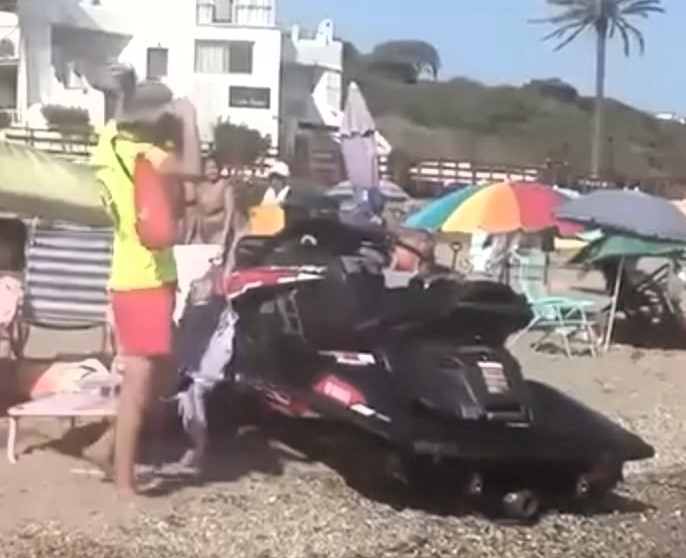 Out-of-control jet ski speeds towards swimmers at La Luna Beach Costa del Sol - startled man falls as beachgoers leap to safety in shocking near-miss caught on video.