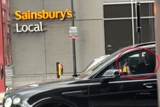 Gary Neville spotted using his phone at the wheel of his £170k Bentley in Salford - shocking fans as footage emerges of the ex-United star risking a driving penalty.