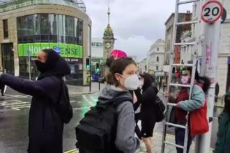 A masked mob tried removing Union Jack flags in Brighton but were confronted by a patriotic local who slammed them for disrespecting England and called them an embarrassment.
