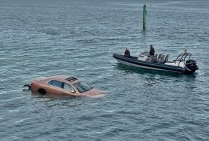 A Bentley plunged into the sea at Sandbanks after falling from a car park, with quick-thinking passers-by pulling the driver through the sunroof before the car sank.