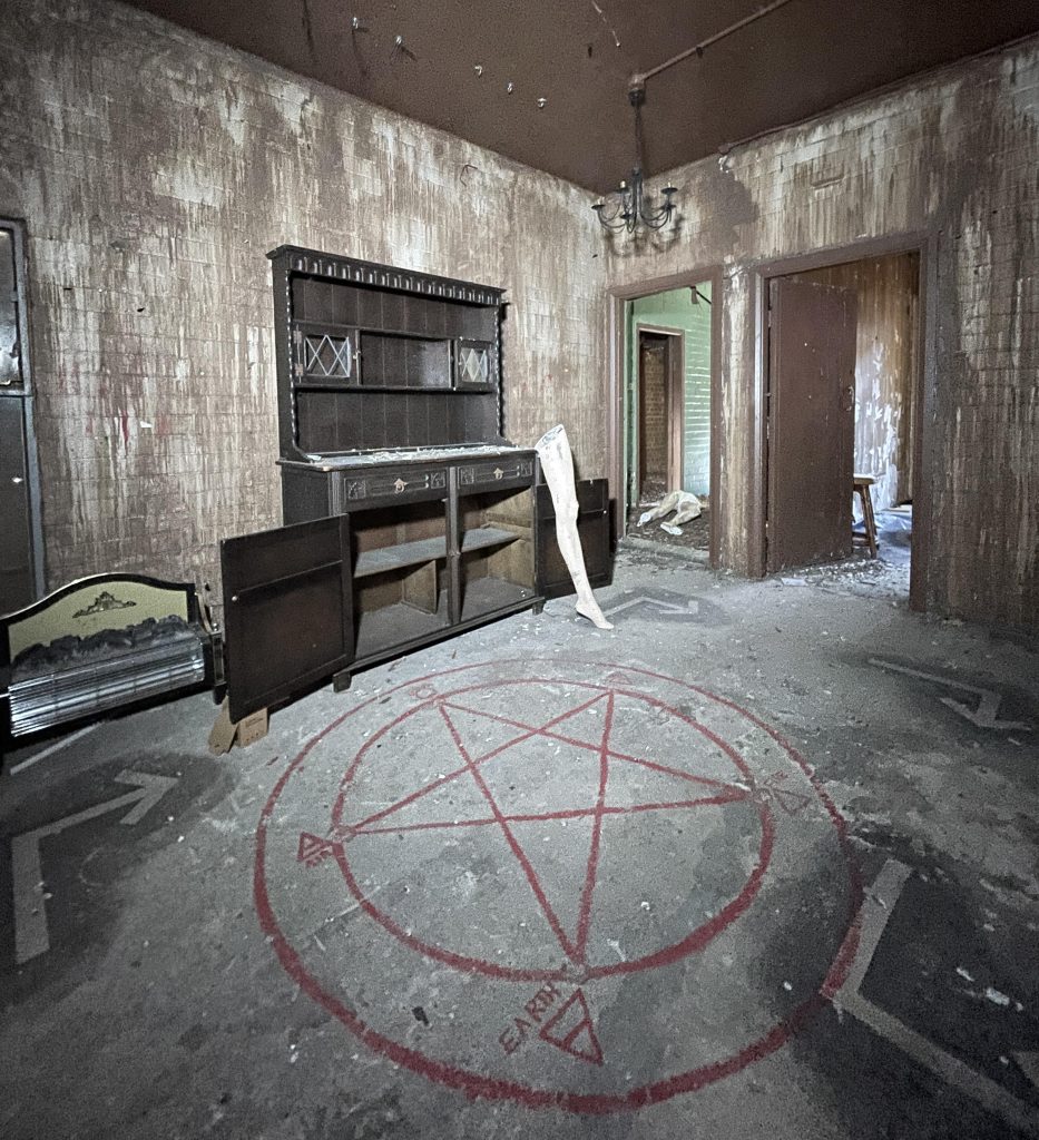 An urban explorer found a derelict museum filled with blood red warnings and a pentagram on the floor describing the eerie abandoned site as something straight out of a horror film.