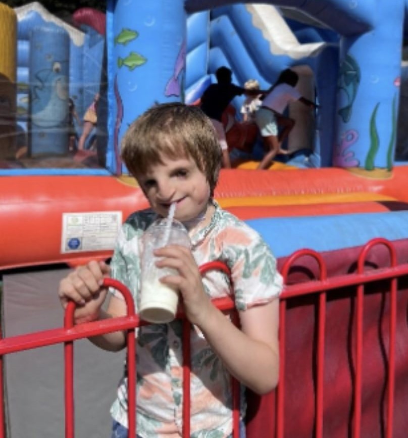 William enjoying a celebratory milkshake at his local park after his tracheostomy tube was removed