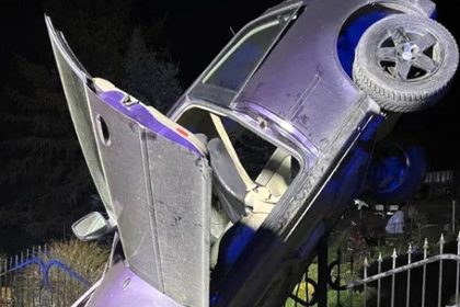 Driver fined after crashing car onto spiked garden fence in Ogorzelec, Poland, leaving it hanging vertically like an action movie scene but miraculously injuring no one.