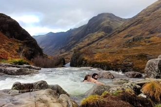 A woman was rescued from being swept over Glencoe waterfall in Scotland after being dragged by a strong current - a brave swimmer pulled her to safety just in time.