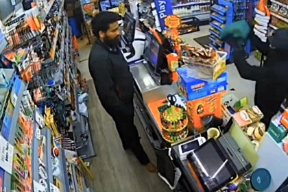 Brave shopkeeper uses a shovel to chase off would be robber who threatened to set him on fire during terrifying till raid caught on CCTV in west London.