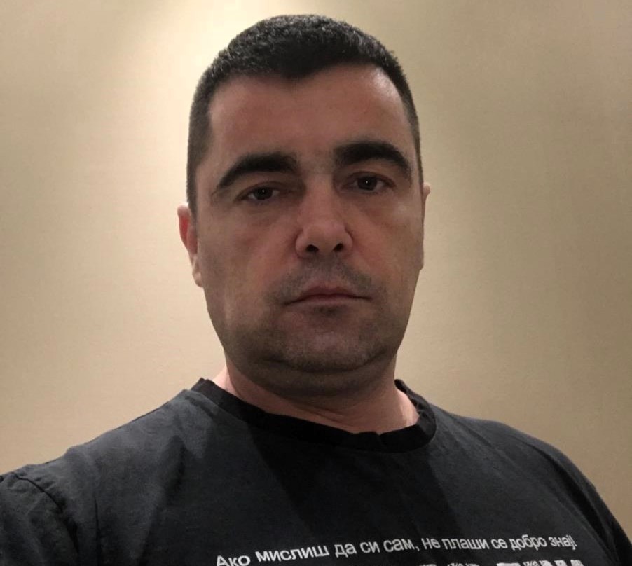 Partizan Belgrade ultra Nenad Alajbegovic survives a tenth assassination attempt after a restaurant shooting in Belgrade as the hunt for the hooded gunman continues amid ongoing conflict.