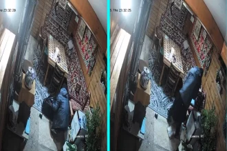 Hooded burglar caught on CCTV ransacking Kent family home on Boxing Day stealing valuables while second man triggered car alarm during midnight raid in Ashford.