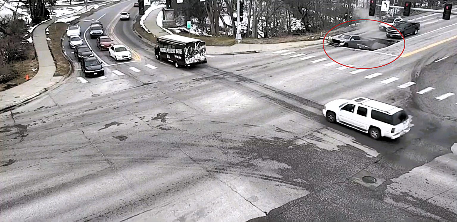 Two cars swallowed by horror sinkhole after road collapses in Omaha - drivers forced to climb out of deep shaft as SUV nearly disappears into the ground.