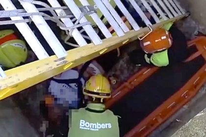 A cemetery worker plunged nearly 10ft into an open grave while cleaning a headstone in Spain - leaving him trapped with a serious back injury until firefighters lowered a ladder to pull him out.