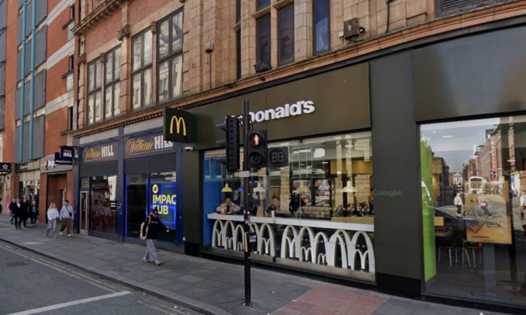 Woman kicked and punched by three attackers outside McDonald's on Oxford Street in Manchester. Shocking gang beating caught on camera as crowd watches victim fall down.
